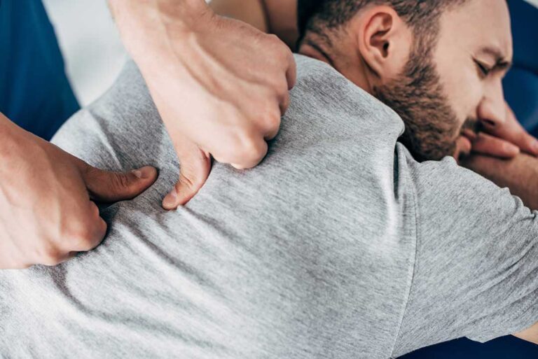 A chiropractor performing a spinal adjustment on an adult patient in a calm clinical office setting.